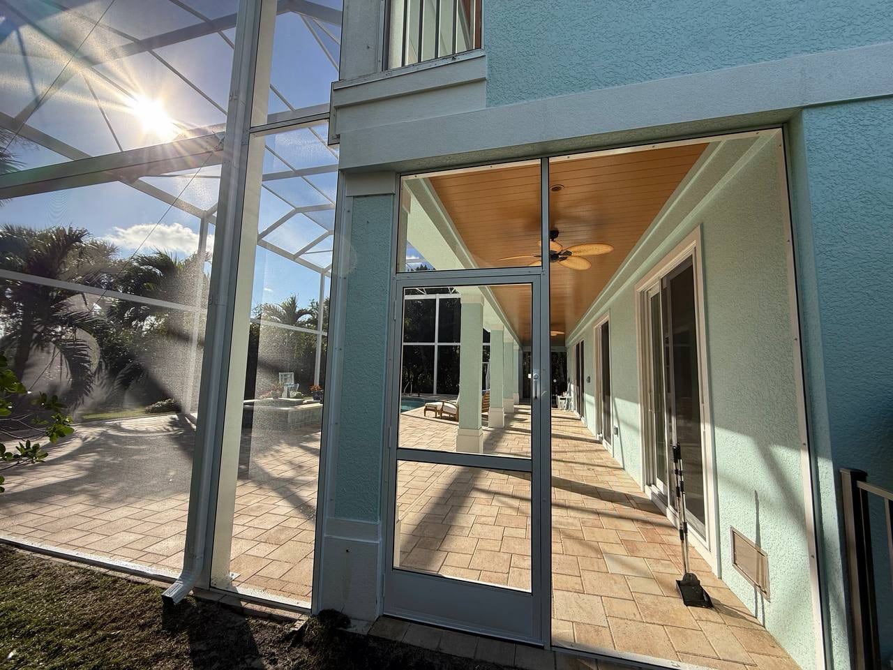Screened patio entrance connecting the home to the pool area