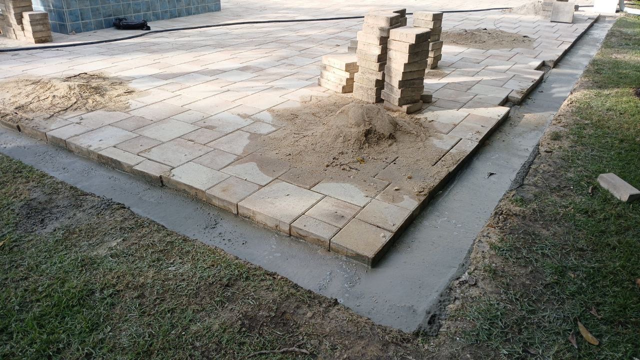 Paver installation and pool deck expansion in progress