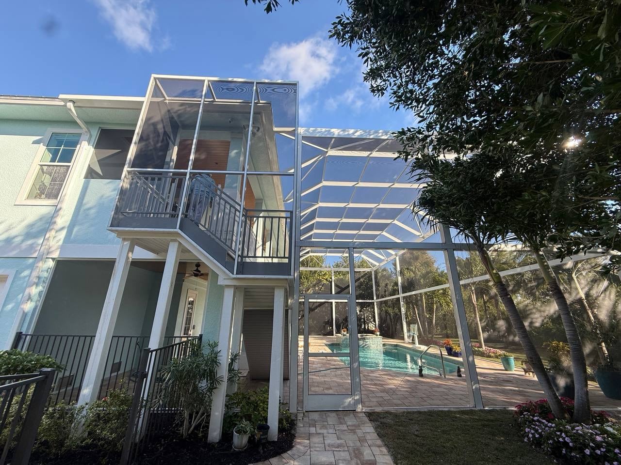 Two story pool enclosure connected to the homes upper balcony