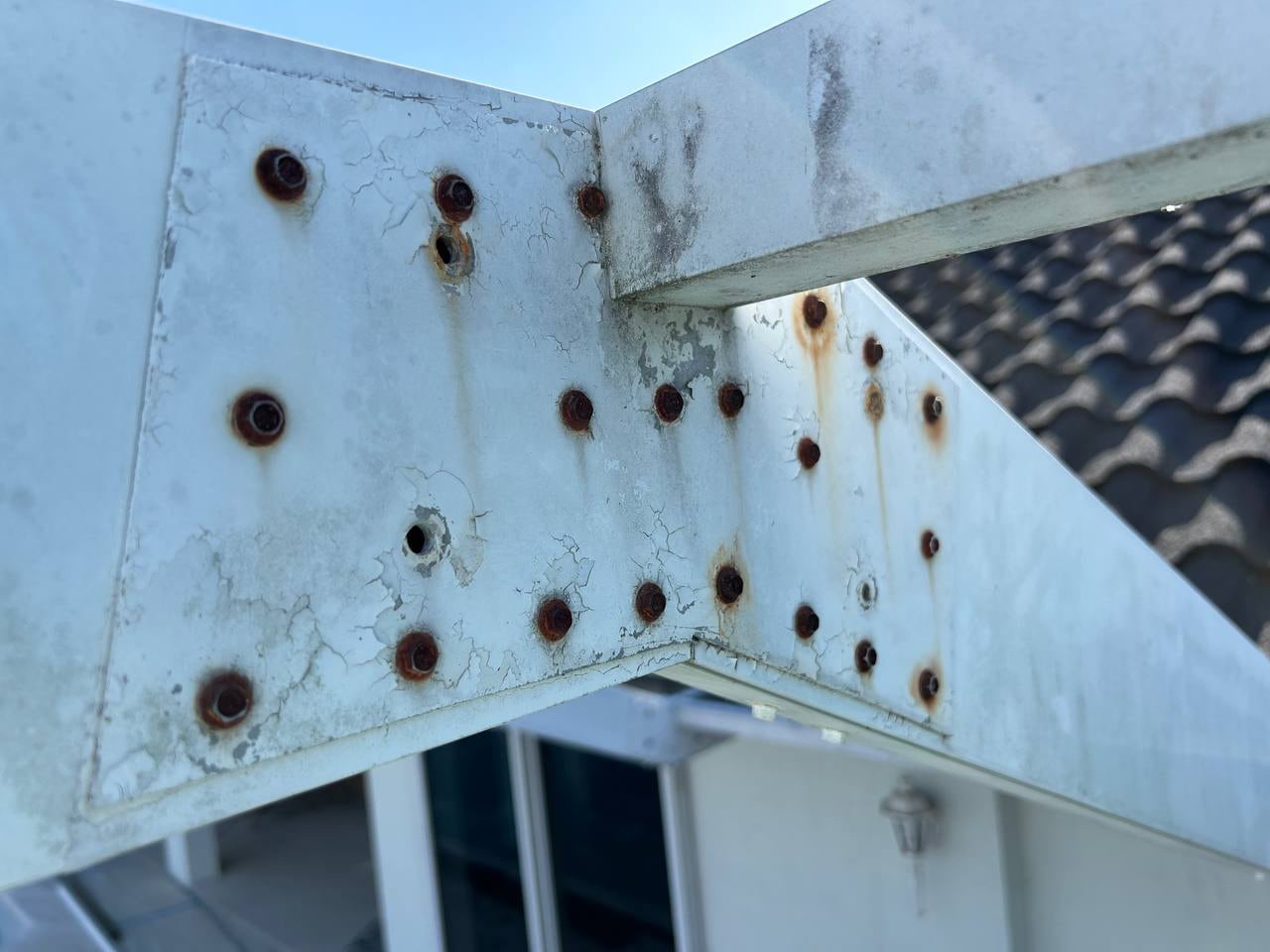 Contractor inspecting an aging aluminum pool cage frame